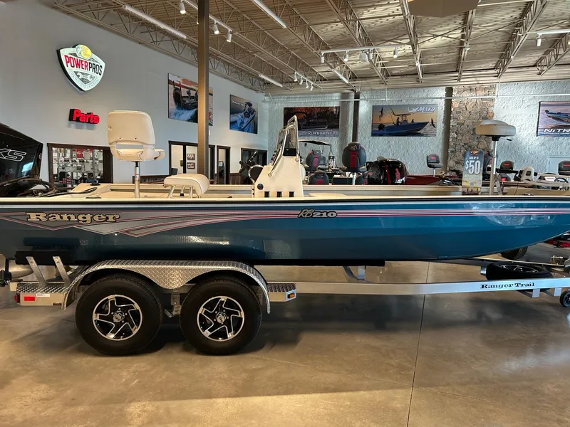 The Image of 2025 Ranger RB210 boat on trailer at dealership, sunny day. - 0