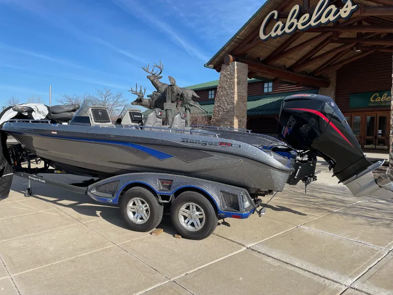 Slide: The Image of 2024 Ranger 620FS Pro boat displayed outside Cabela's store, featuring sleek design and powerful engine. - 0