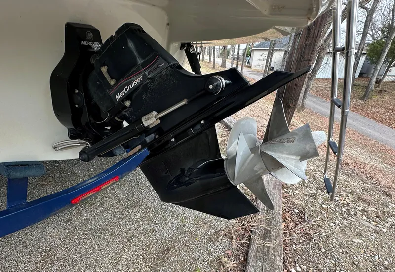 Slide: The Image of 2018 Crownline Eclipse E25 boat with MerCruiser outdrive and propeller, parked on gravel. - 23