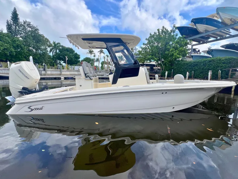 The Image of 2025 Scout 261 XSS boat docked on calm water, surrounded by lush greenery and clear skies. - 0