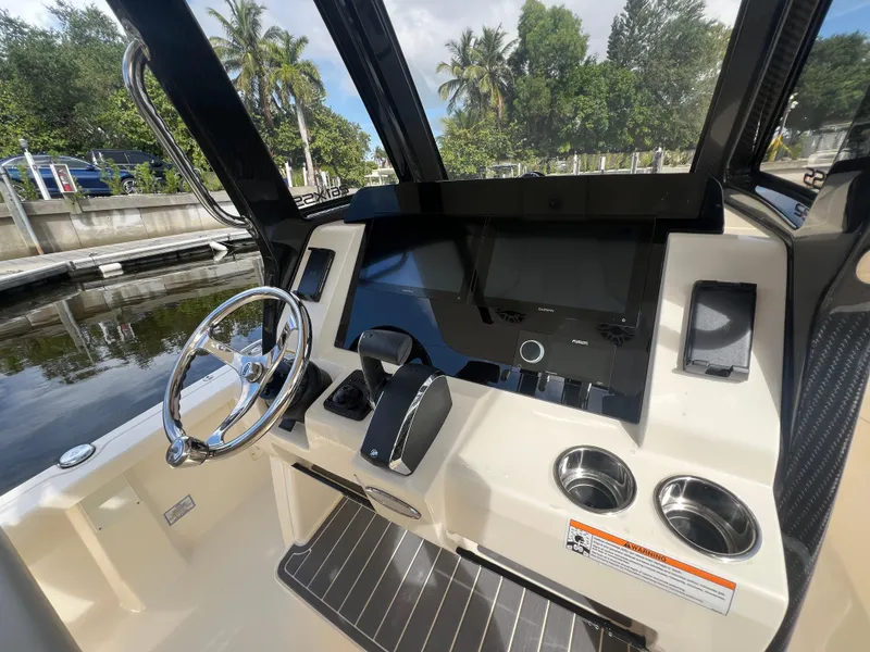Slide: The Image of 2025 Scout 261 XSS boat dashboard with steering wheel, touchscreen, and cup holders. - 11