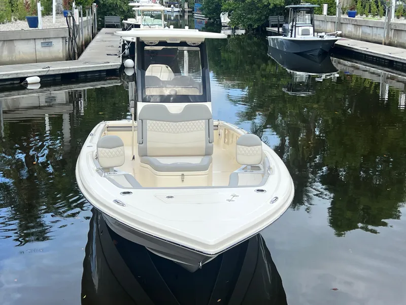 Slide: The Image of 2025 Scout 261 XSS boat docked in a serene marina setting. - 4