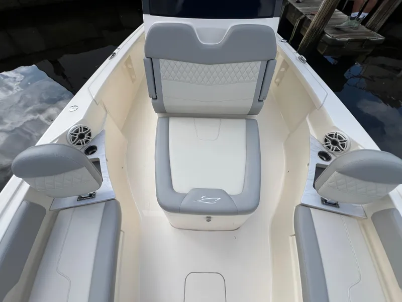 Slide: The Image of 2025 Scout 261 XSS boat interior with gray and white seating, cup holders, and speakers. - 7
