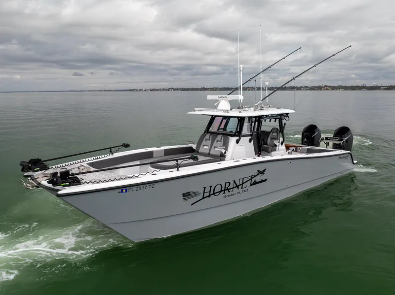 Slide: The Image of 2022 Freeman 37 VH boat on calm water, equipped with fishing rods and twin engines. - 13