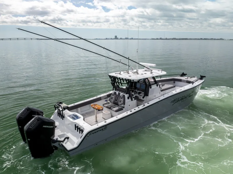 Slide: The Image of 2022 Freeman 37 VH boat on calm water, equipped with dual engines and fishing rods. - 15