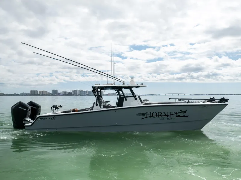 Slide: The Image of 2022 Freeman 37 VH boat on water, equipped with fishing gear, under cloudy sky. - 16