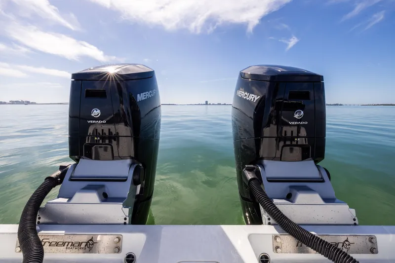 Slide: The Image of Twin Mercury outboard engines on a 2022 Freeman 37 VH boat, calm sea background. - 20