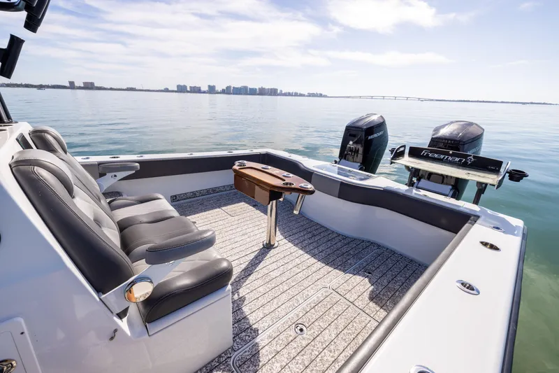 Slide: The Image of Freeman 37 VH 2022 boat interior with seating and twin engines on calm water. - 23
