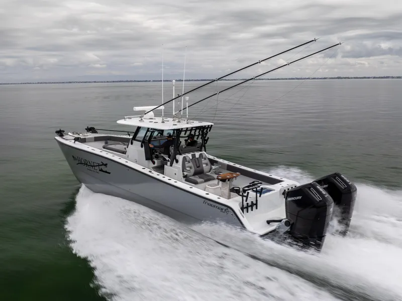 Slide: The Image of 2022 Freeman 37 VH boat cruising on calm water, equipped with dual outboard engines. - 3