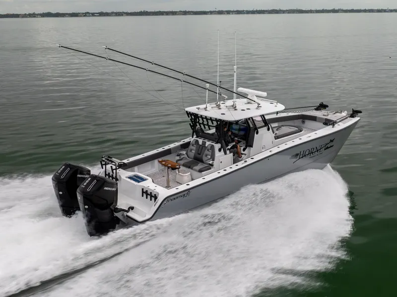 Slide: The Image of 2022 Freeman 37 VH boat cruising on calm water, equipped with dual outboard motors. - 5