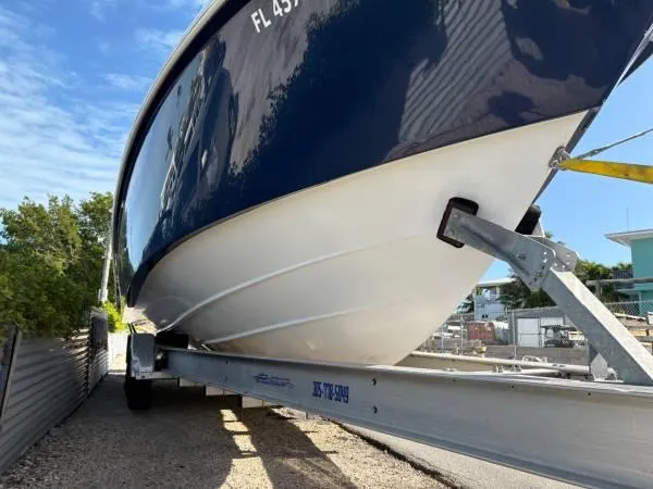 Slide: The Image of 2012 Everglades 325 Center Console boat on trailer, blue hull, sunny day. - 5