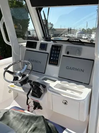 Slide: The Image of 2012 Everglades 325 Center Console boat cockpit with Garmin navigation displays. - 8