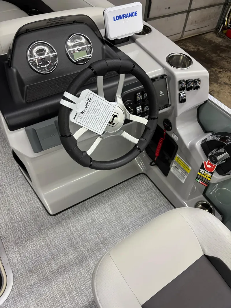 Slide: The Image of 2025 Harris CRUISER 230 SLDH boat dashboard with steering wheel and Lowrance display. - 10