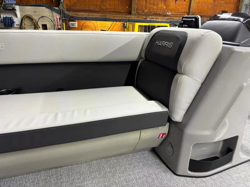 Slide: The Image of 2025 Harris CRUISER 230 SLDH boat interior with gray seating and branded upholstery. - 16
