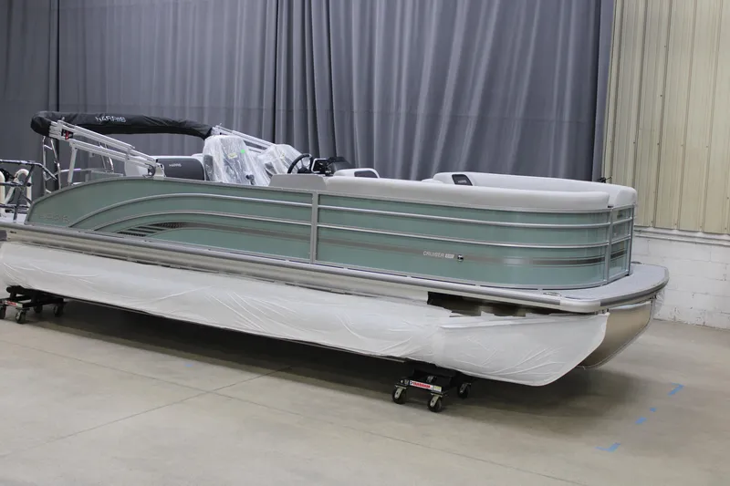 Slide: The Image of 2025 Harris CRUISER 230 SLDH pontoon boat in a showroom, side view. - 2