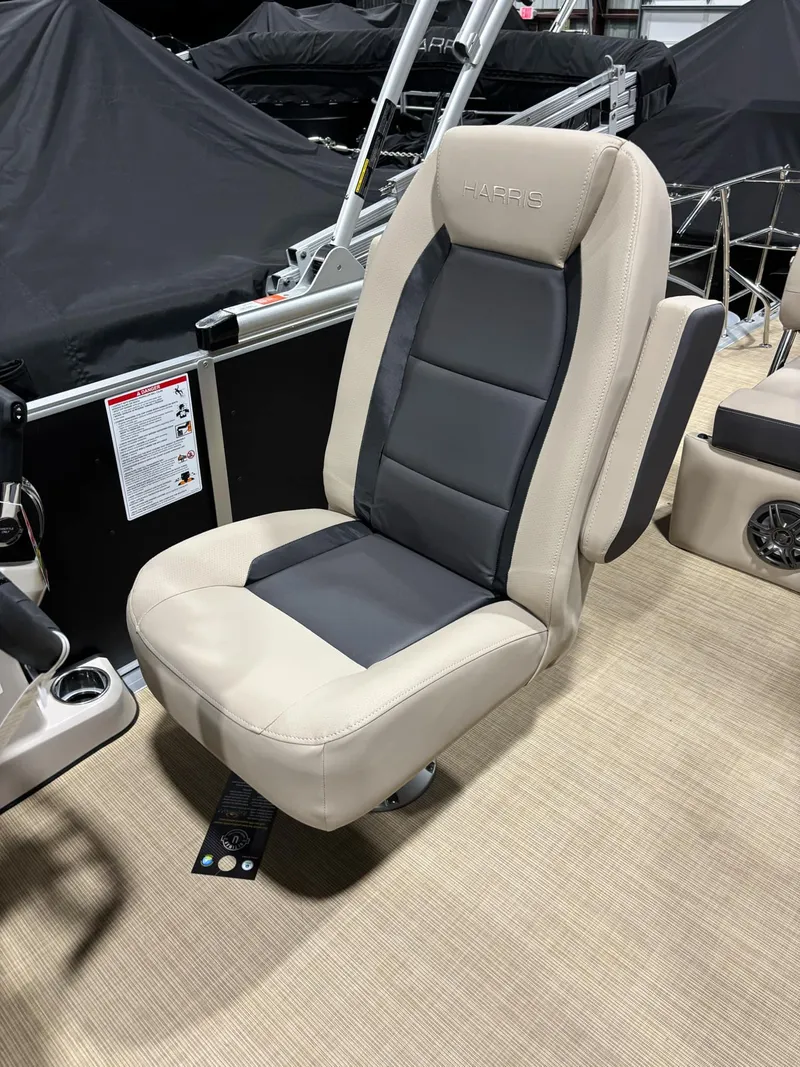 Slide: The Image of 2025 Harris CRUISER 230 SLDH boat seat, beige and black upholstery, indoor setting. - 4