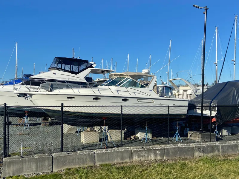 Slide: The Image of 2000 Tiara Yachts 3100 Open docked in a marina with clear blue sky. - 1