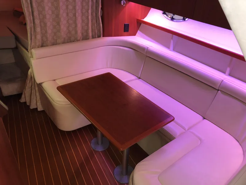 Slide: The Image of 2000 Tiara Yachts 3100 Open interior with white seating and wooden table. - 21