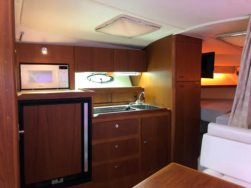 Slide: The Image of Interior of 2000 Tiara Yachts 3100 Open, featuring kitchenette with microwave and sink. - 22