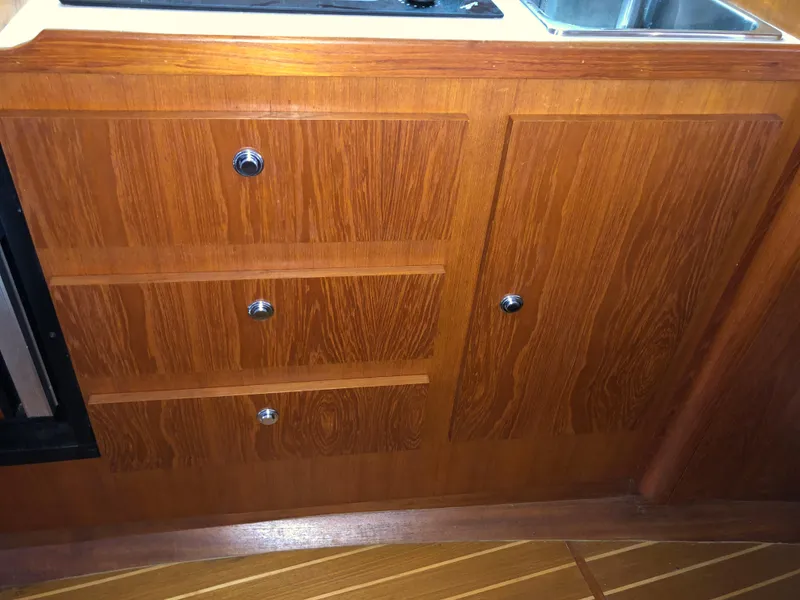 Slide: The Image of Wooden cabinetry in 2000 Tiara Yachts 3100 Open, featuring drawers and a sink area. - 26