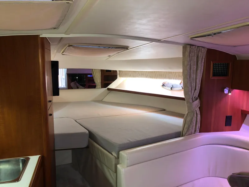 Slide: The Image of Interior of 2000 Tiara Yachts 3100 Open, featuring cozy cabin and elegant wood finishes. - 29