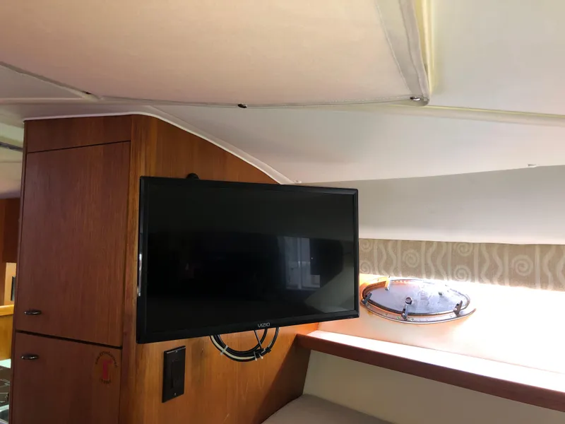 Slide: The Image of Interior of 2000 Tiara Yachts 3100 Open with mounted TV and wooden cabinetry. - 30