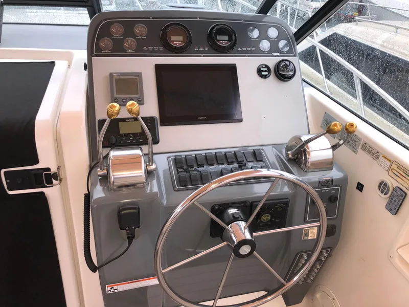 Slide: The Image of Helm of 2000 Tiara Yachts 3100 Open with steering wheel and control panel. - 6