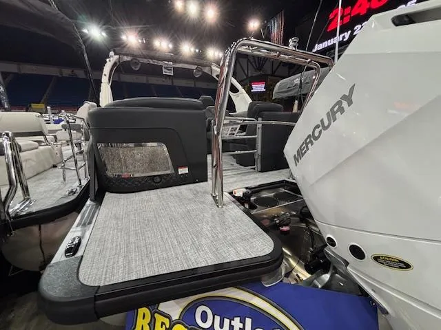 Slide: The Image of 2025 Harris Grand Mariner 250 boat with Mercury engine, showcased indoors under bright lights. - 45