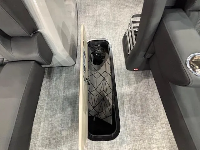 Slide: The Image of 2025 Harris Grand Mariner 250 interior storage compartment with open hatch, gray seating, and carpeted floor. - 9