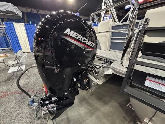 Slide: The Image of 2025 Harris Sunliner 230 CWDH with Mercury outboard motor at a boat show. - 2