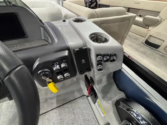 Slide: The Image of Control panel of 2025 Harris Sunliner 230 CWDH boat with switches and cup holders. - 9