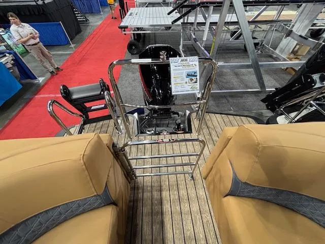 Slide: The Image of 2025 Harris Solstice 230 boat interior with tan seating and wood flooring at a showroom. - 10