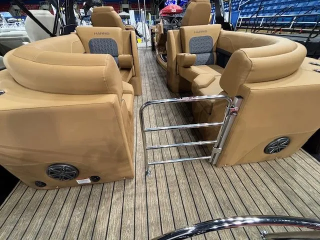 Slide: The Image of 2025 Harris Solstice 230 boat interior with tan seating and wood flooring. - 11