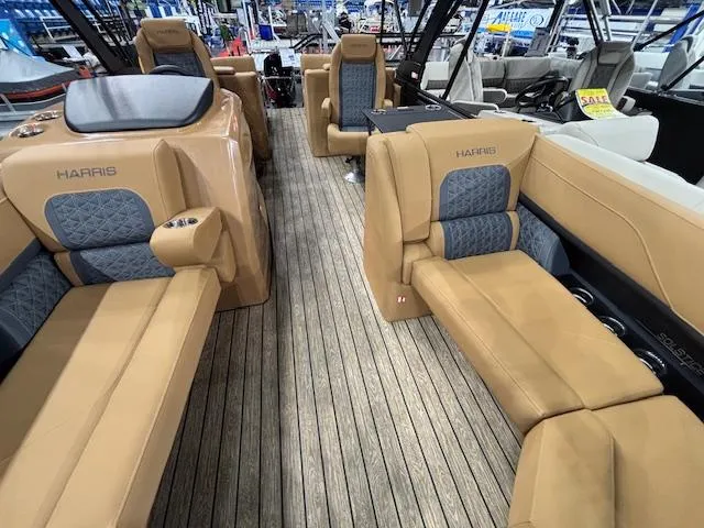 Slide: The Image of 2025 Harris Solstice 230 boat interior with tan and blue seating on wooden deck. - 4