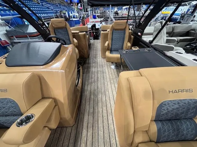 Slide: The Image of 2025 Harris Solstice 230 boat interior with tan and blue seating, wooden flooring. - 5
