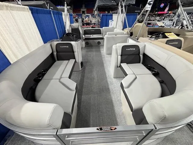 Slide: The Image of 2025 Harris Cruiser 210 SL pontoon boat with spacious seating and modern design at a boat show. - 24