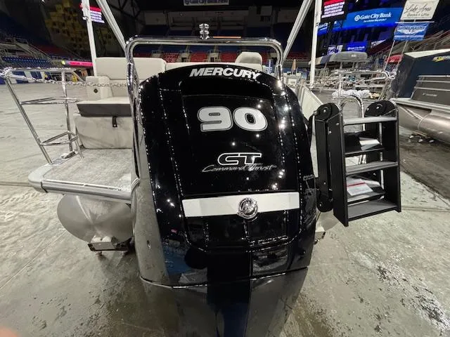 Slide: The Image of 2025 Harris Cruiser 210 SL with Mercury 90 CT outboard engine at indoor display. - 3