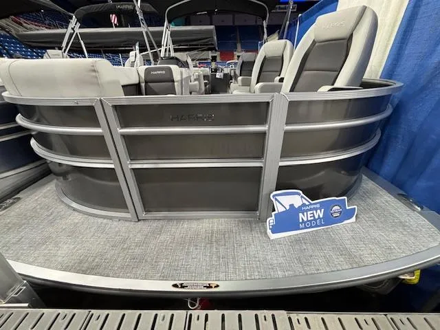 Slide: The Image of 2025 Harris Cruiser 230 pontoon boat on display with new model sign. - 6