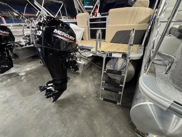 Slide: The Image of 2025 Harris Cruiser 190 pontoon boat with Mercury outboard motor and boarding ladder. - 12