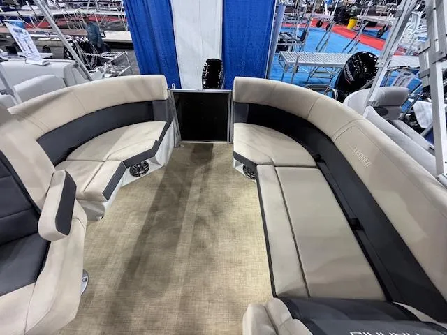 Slide: The Image of 2025 Harris Cruiser 190 interior with beige and black seating at a boat show. - 9