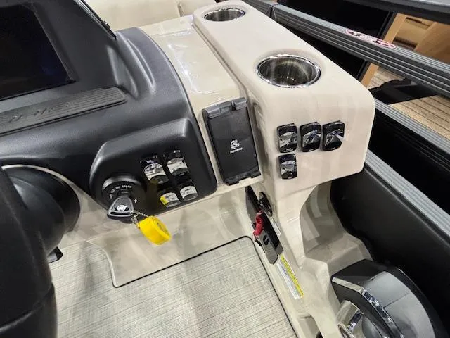 Slide: The Image of Control panel of 2025 Harris SUNLINER 230 SLDH boat with switches and cup holders. - 12