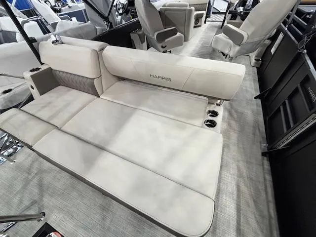 Slide: The Image of 2025 Harris SUNLINER 230 SLDH boat interior with beige seating and cup holders. - 16