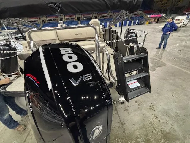 Slide: The Image of 2025 Harris SUNLINER 230 SLDH boat with 200 V6 engine, displayed indoors. - 3