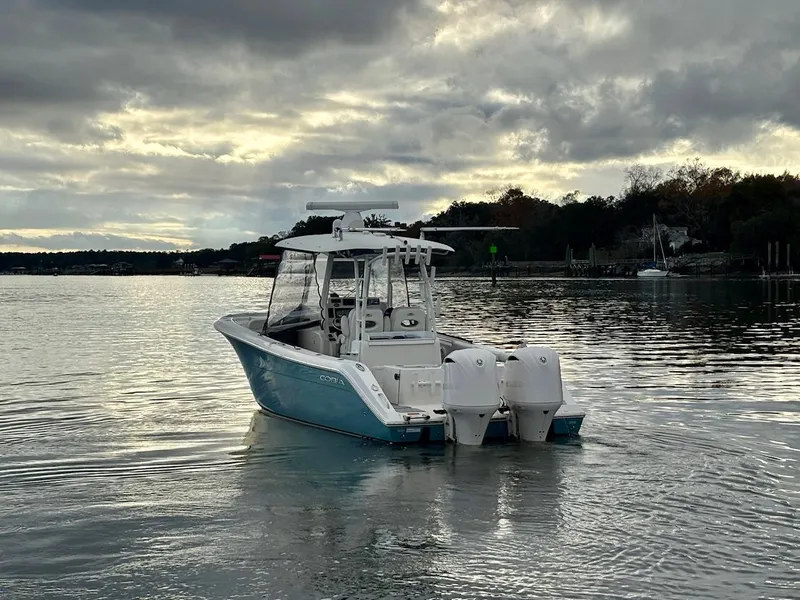Slide: The Image of 2019 Cobia 301 Center Console boat on calm water under cloudy sky. - 3