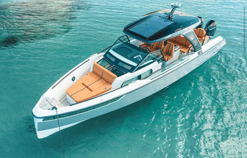 Slide: The Image of 2025 Saxdor 320 GTO boat on clear turquoise water, featuring sleek design and orange seating. - 6