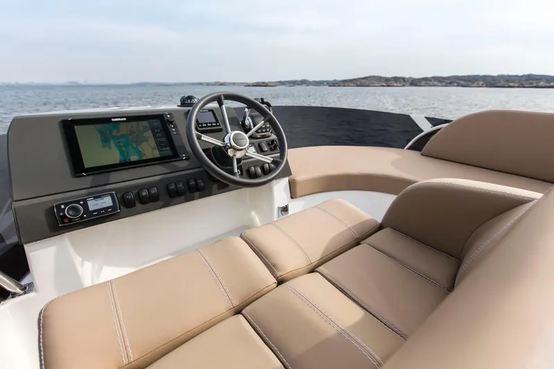 Slide: The Image of Luxurious 2025 Nimbus 405 Flybridge helm with beige seating and advanced navigation system. - 4