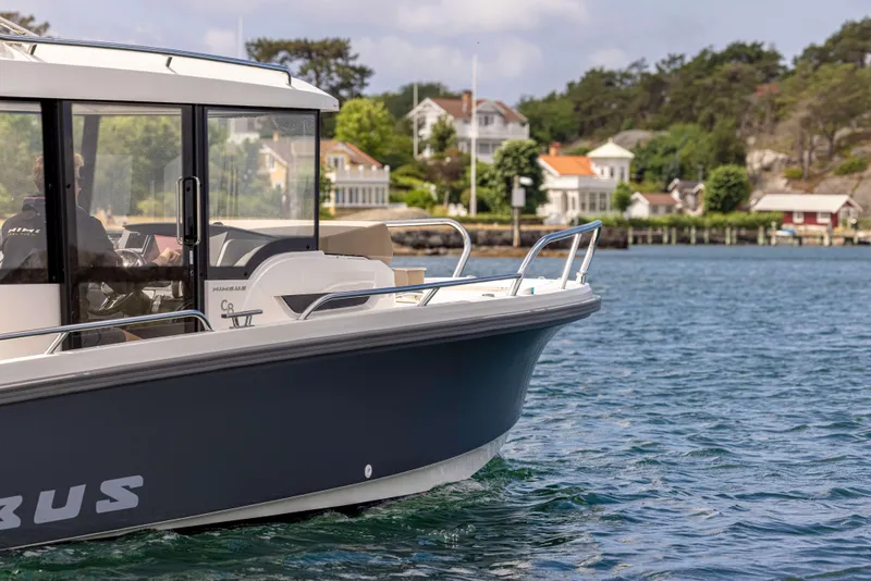 Slide: The Image of Nimbus Commuter 8 boat on water, 2025 model, near scenic shoreline houses. - 10