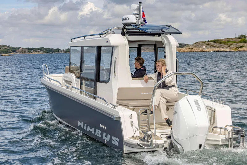 Slide: The Image of 2025 Nimbus Commuter 8 boat cruising on open water, featuring modern design and spacious cabin. - 12