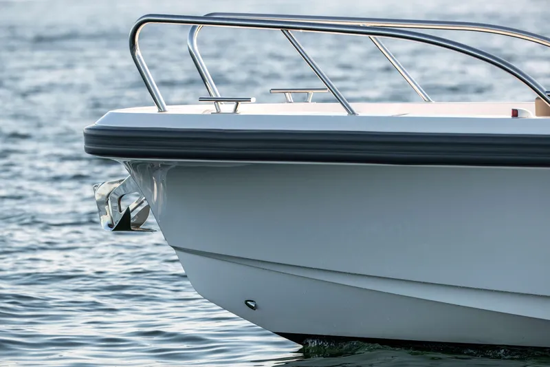 Slide: The Image of 2025 Nimbus Commuter 9 boat on water, featuring sleek design and stainless steel railings. - 19