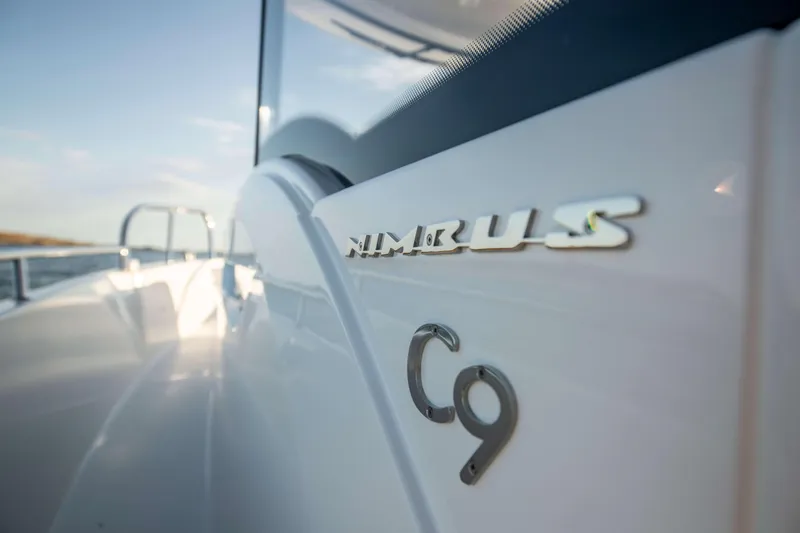 Slide: The Image of 2025 Nimbus Commuter 9 boat, sleek white exterior with logo detail. - 23